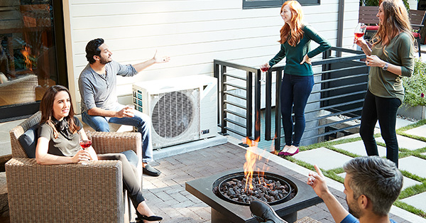 Group of people relaxing around a Daikin unit